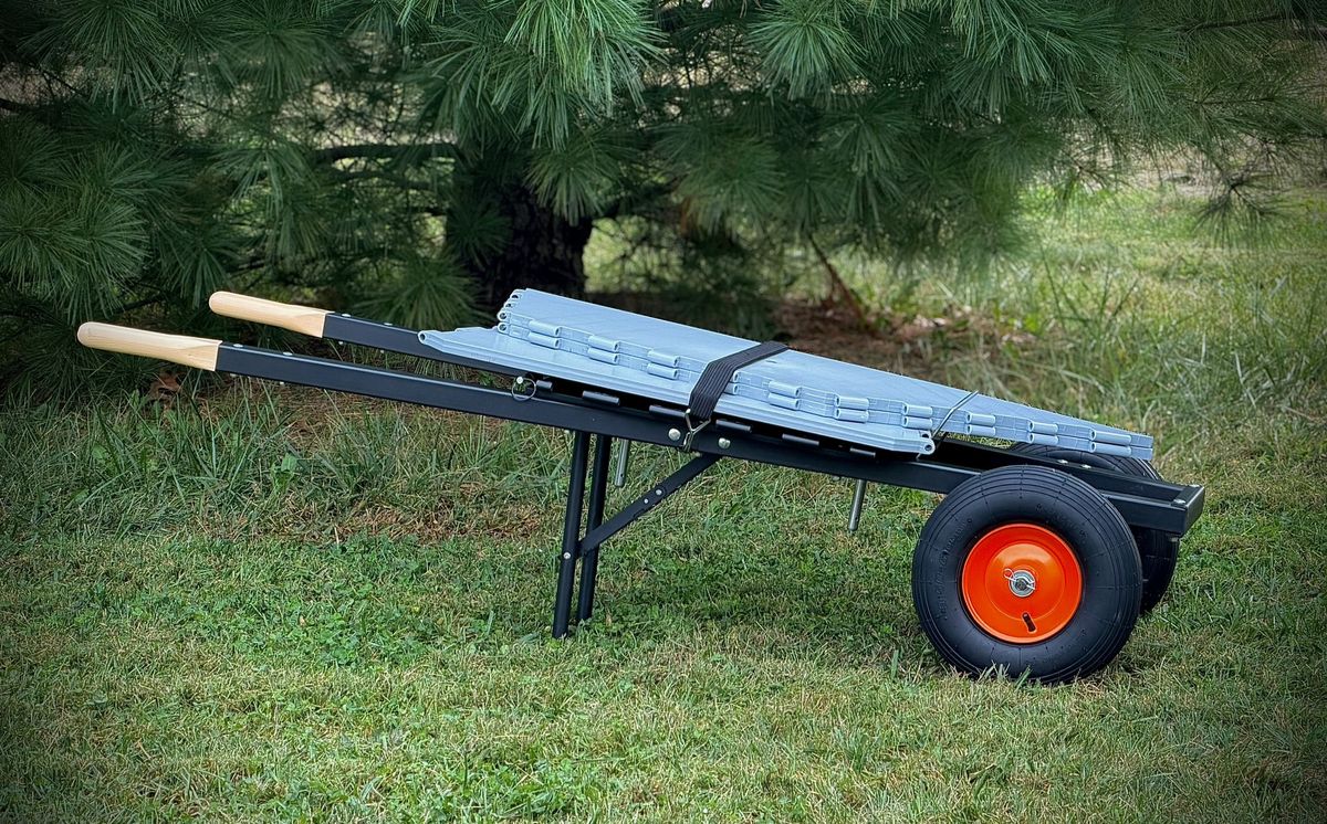 The same wheelbarrow collapsed, panels strapped flat on the base