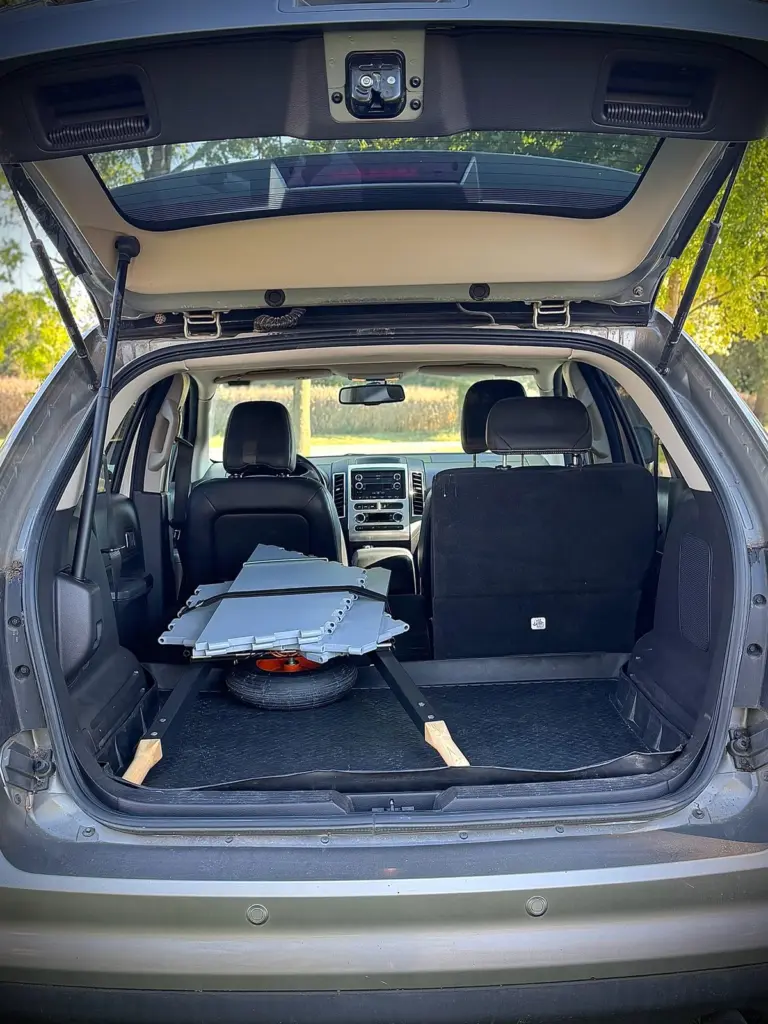 Collapsed flat in the cargo area of an SUV — no shed and no truck needed